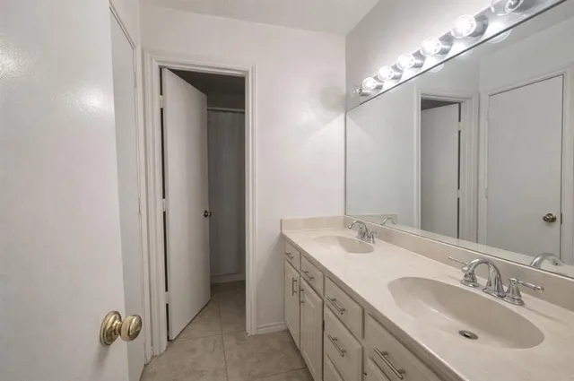 a bathroom with a double vanity sink and a mirror
