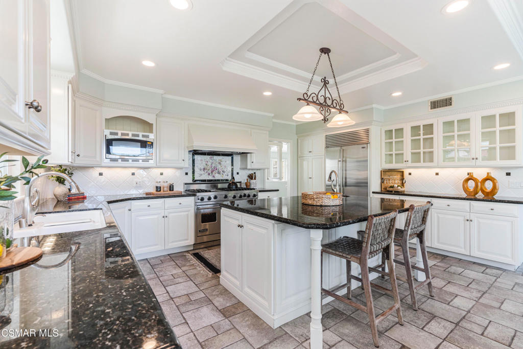 637 Bluegrass Street Simi Valley, CA 93065 - Photo 24 of 67 a kitchen with a sink dining table and chairs