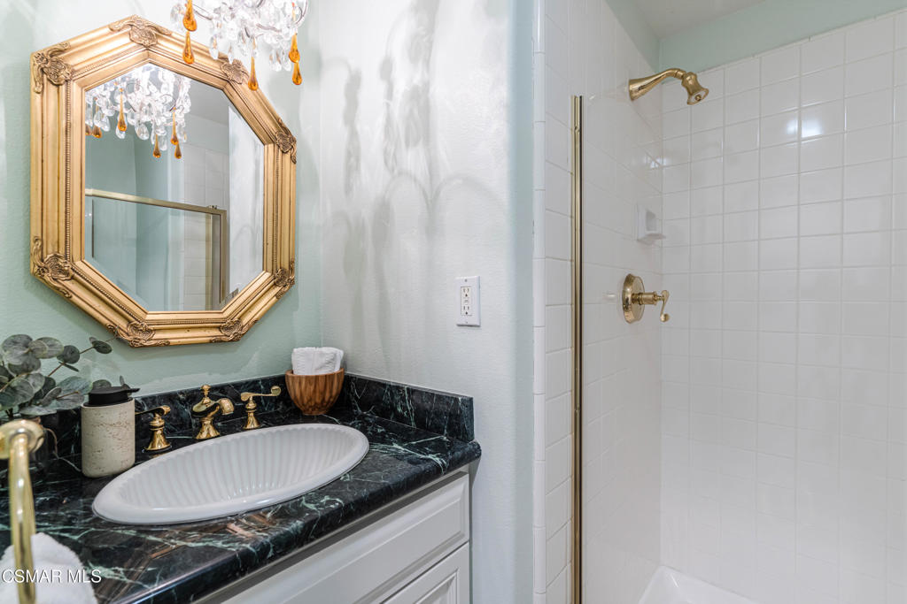 637 Bluegrass Street Simi Valley, CA 93065 - Photo 31 of 67 a bathroom with a granite countertop sink a mirror and a shower