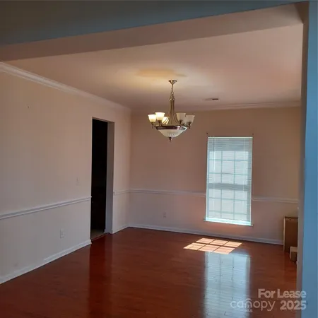 an empty room with windows and wooden floor