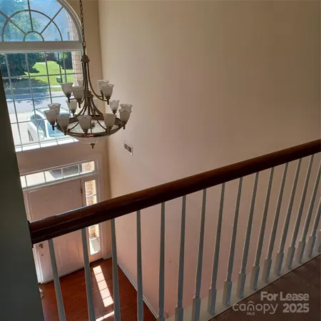 a view of staircase with railing and a window
