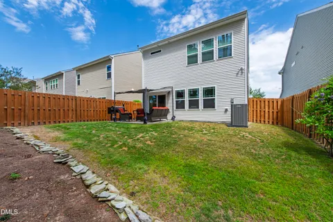 a view of a house with backyard and a tree