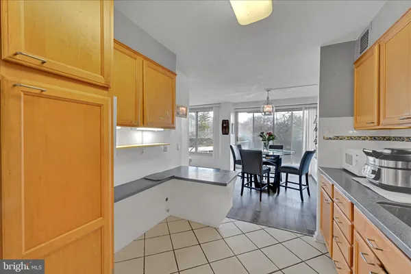 a dining hall with stainless steel appliances a dining table and chairs