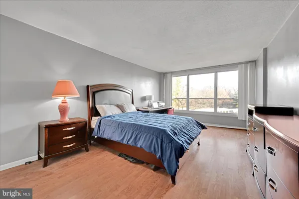 a bedroom with a bed and a large window