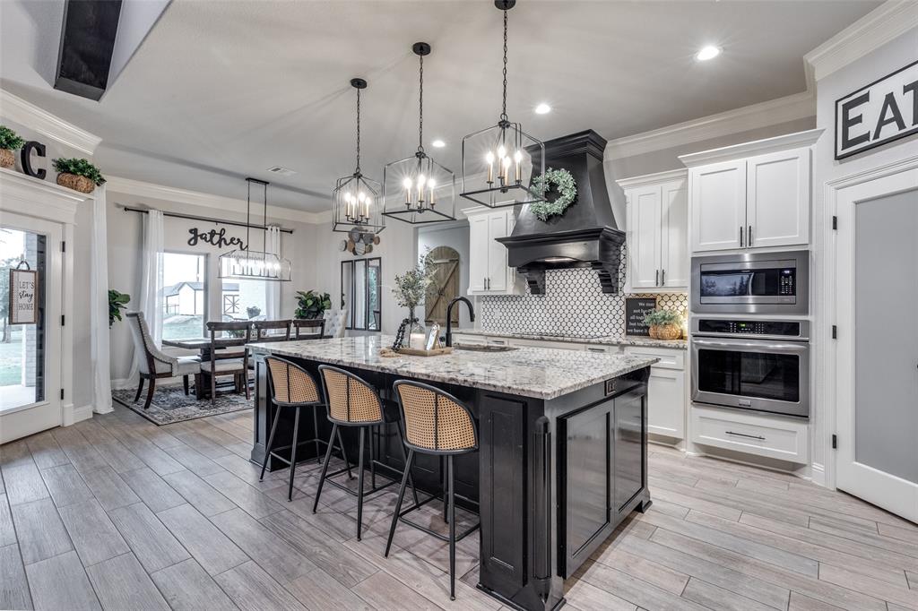109 Highland Ranch Drive Paradise, TX 76073 - Photo 11 of 33 a kitchen with granite countertop a table chairs stainless steel appliances and wooden floor