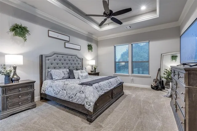 a bedroom with a bed a ceiling fan and a dresser