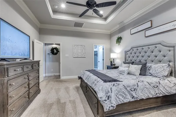 a spacious bedroom with a bed and dresser