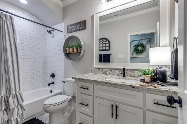 a bathroom with a granite countertop toilet sink and mirror