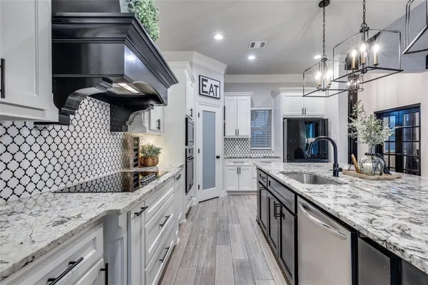 a kitchen with stainless steel appliances granite countertop a sink a oven and a refrigerator