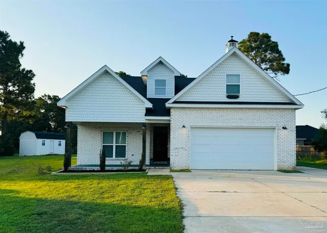 a front view of house with yard and garage