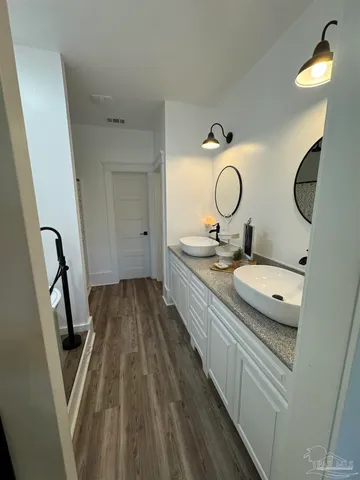a bathroom with a granite countertop sink toilet and a mirror