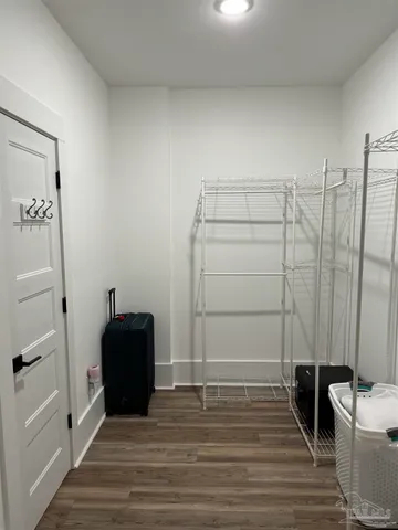 a room with a walk in closet and wooden floor