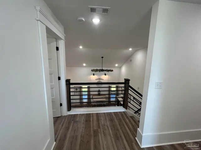 a bedroom with a bed and a table with wooden floor