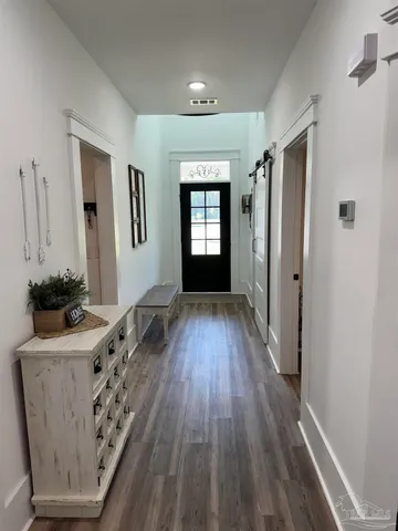 a view of a living room hardwood floor and an empty room