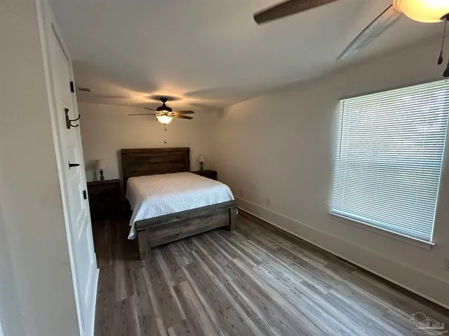 a bedroom with a bed and wooden floor