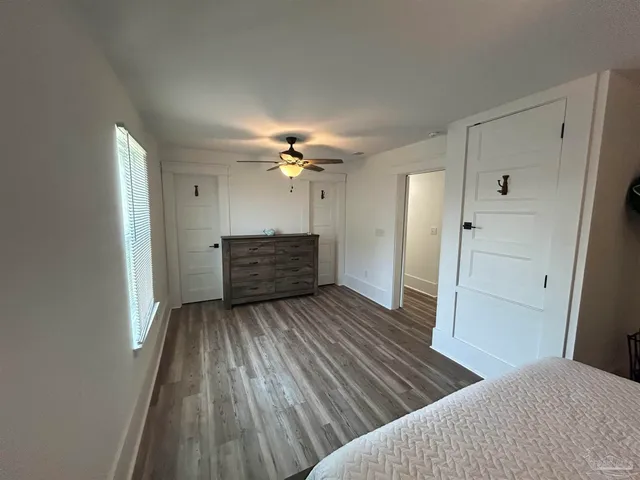 a view of a livingroom with wooden floor and a ceiling fan