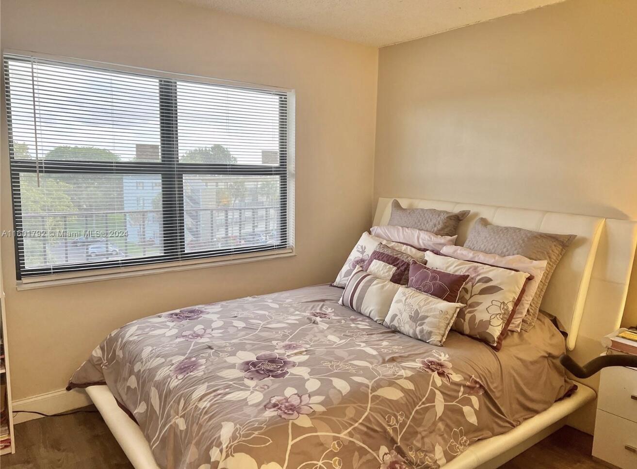 9235 Southwest 8th Street, Unit 507 Boca Raton, FL 33428 - Photo 10 of 16 a bed sitting in a bedroom next to a window