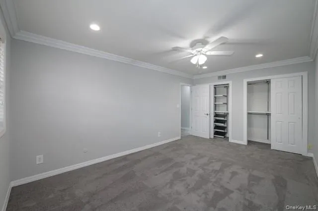 an empty room with closet and a ceiling fan