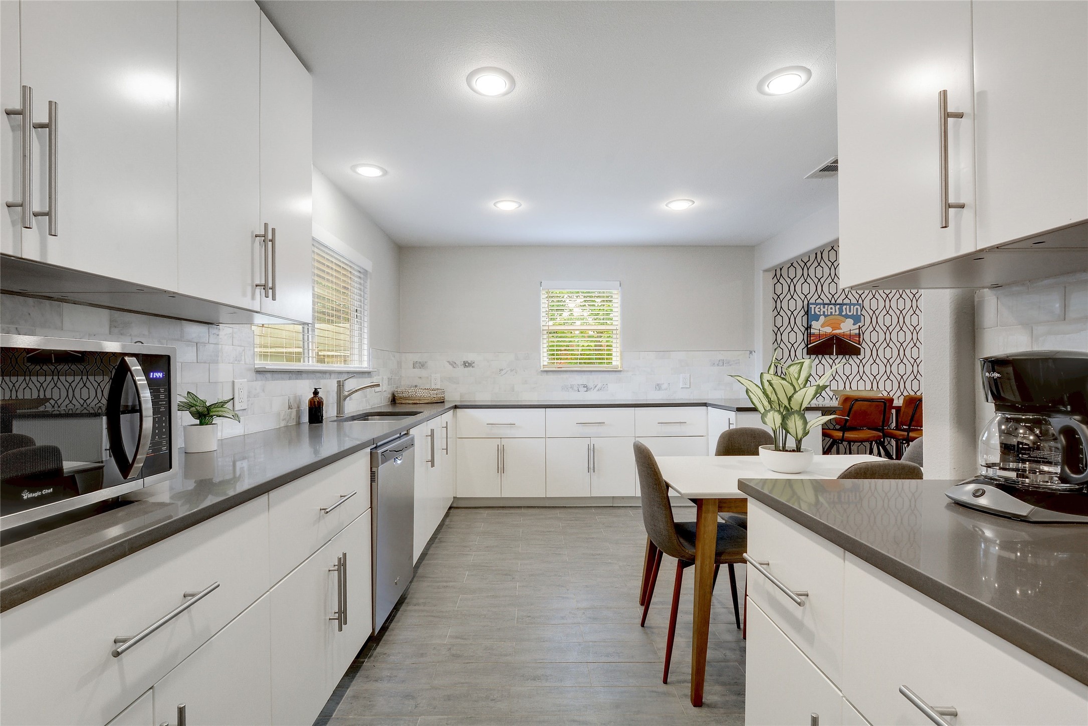 Undisclosed Address Austin, TX 78721 - Photo 12 of 35 Kitchen with stainless steel appliances, white cabinetry, tasteful backsplash, and dark wood-type flooring