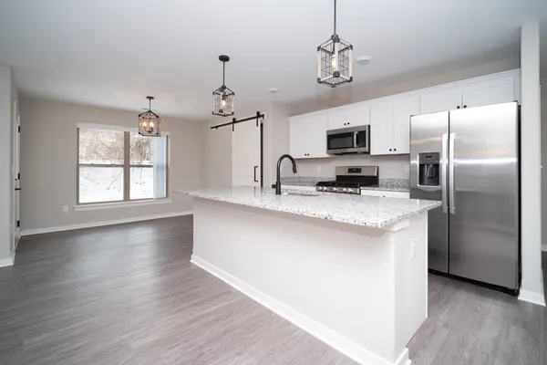 a kitchen with kitchen island a stove a sink a refrigerator and a fireplace