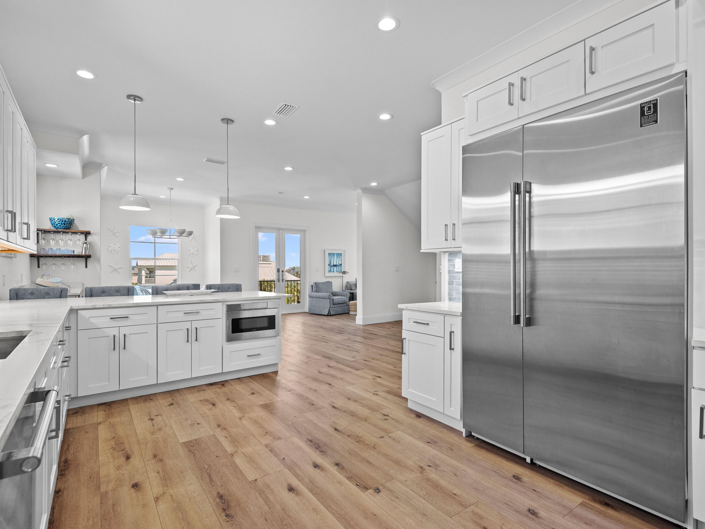 50 Camelot Lane Santa Rosa Beach, FL 32459 - Photo 7 of 39 an open kitchen with white cabinets and stainless steel appliances