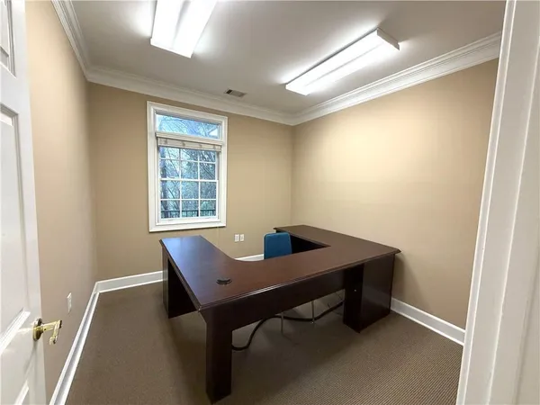 a view of a workspace with furniture and a window