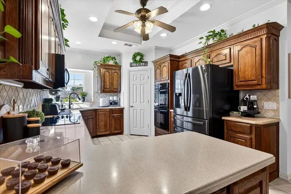 a kitchen with stainless steel appliances granite countertop a refrigerator a stove top oven a sink dishwasher and wooden cabinets