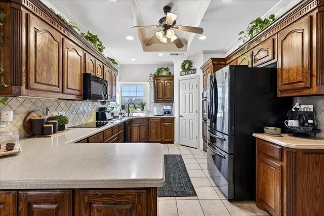 a kitchen with stainless steel appliances granite countertop a sink refrigerator and cabinets