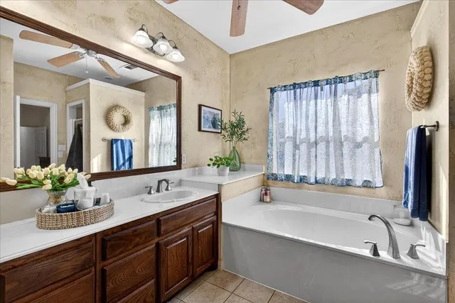 a bathroom with a tub sink and mirror