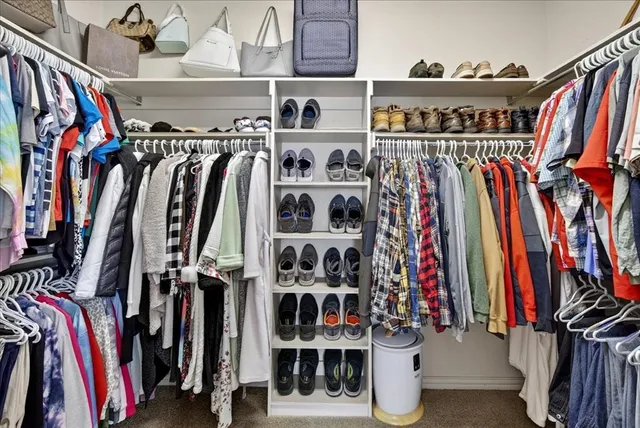 a view of walk in closet with clothes and shoes