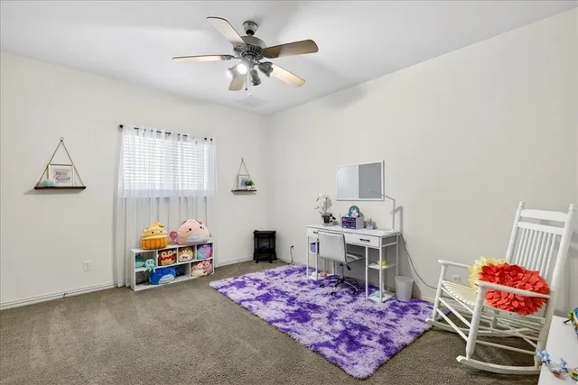 a bedroom with furniture and a chandelier fan