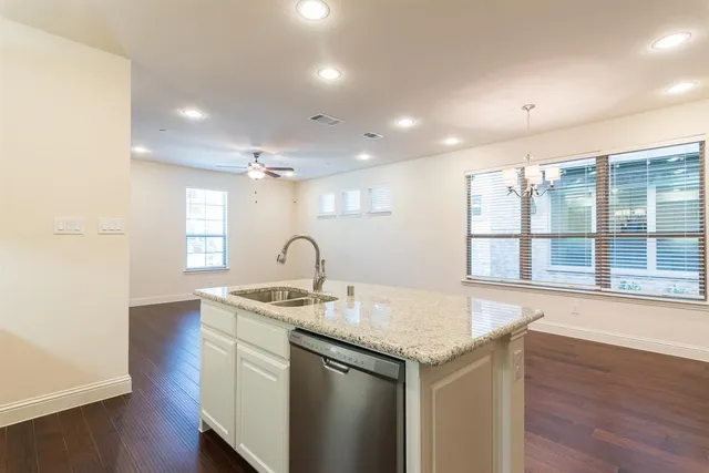 a kitchen with granite countertop kitchen island a sink appliances and a counter space