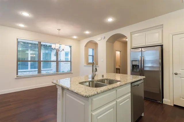 a kitchen with stainless steel appliances granite countertop a sink and a large window