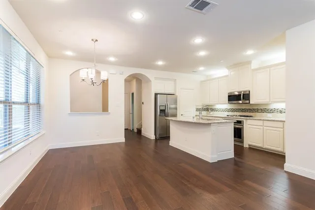 a view of kitchen with sink and refrigerator