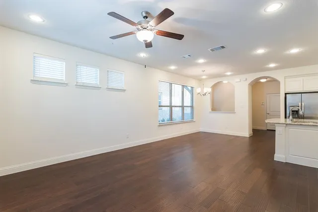 a view of an empty room with window and wooden floor