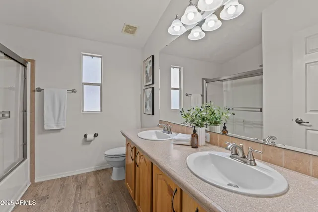 a bathroom with a sink double vanity granite and a toilet