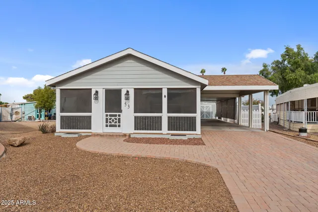 a front view of a house with a yard and seating space