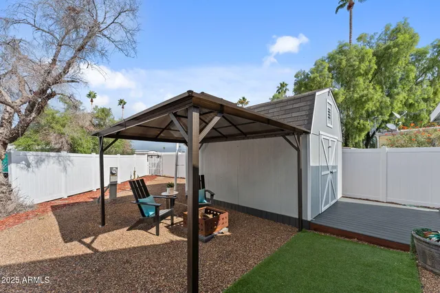 a view of backyard with table and chairs and potted plants