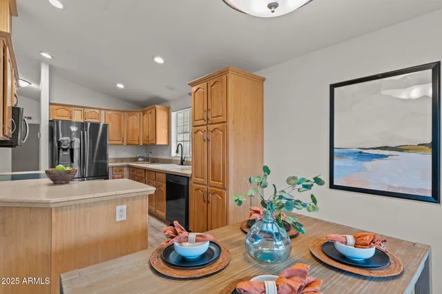 a kitchen with stainless steel appliances kitchen island granite countertop a dining table and chairs