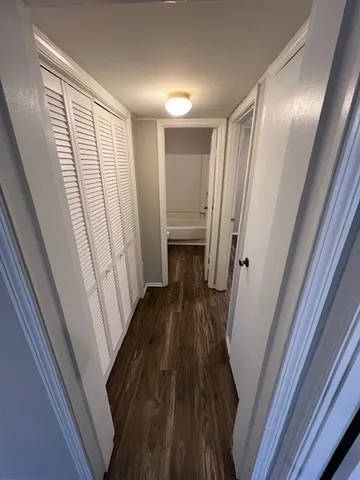 a view of a hallway with wooden floor and staircase