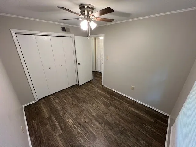 a view of an empty room with a fan and a window