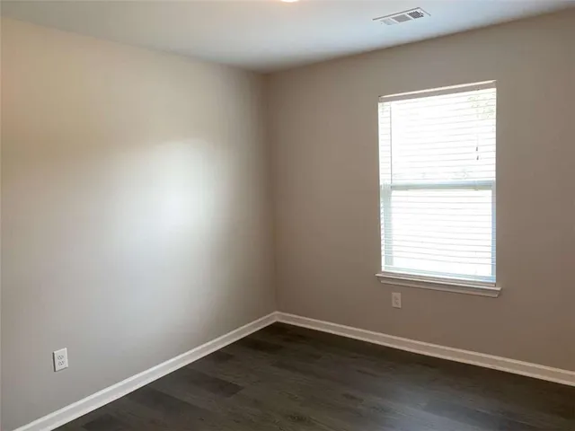 a view of a small space with wooden floor and a window