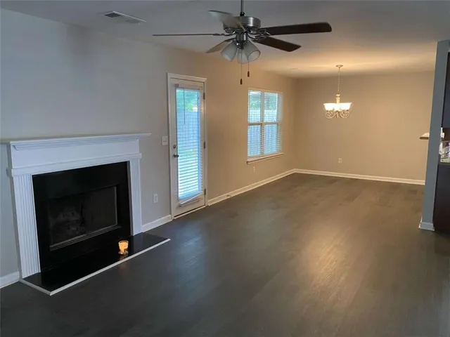 an empty room with windows and fireplace