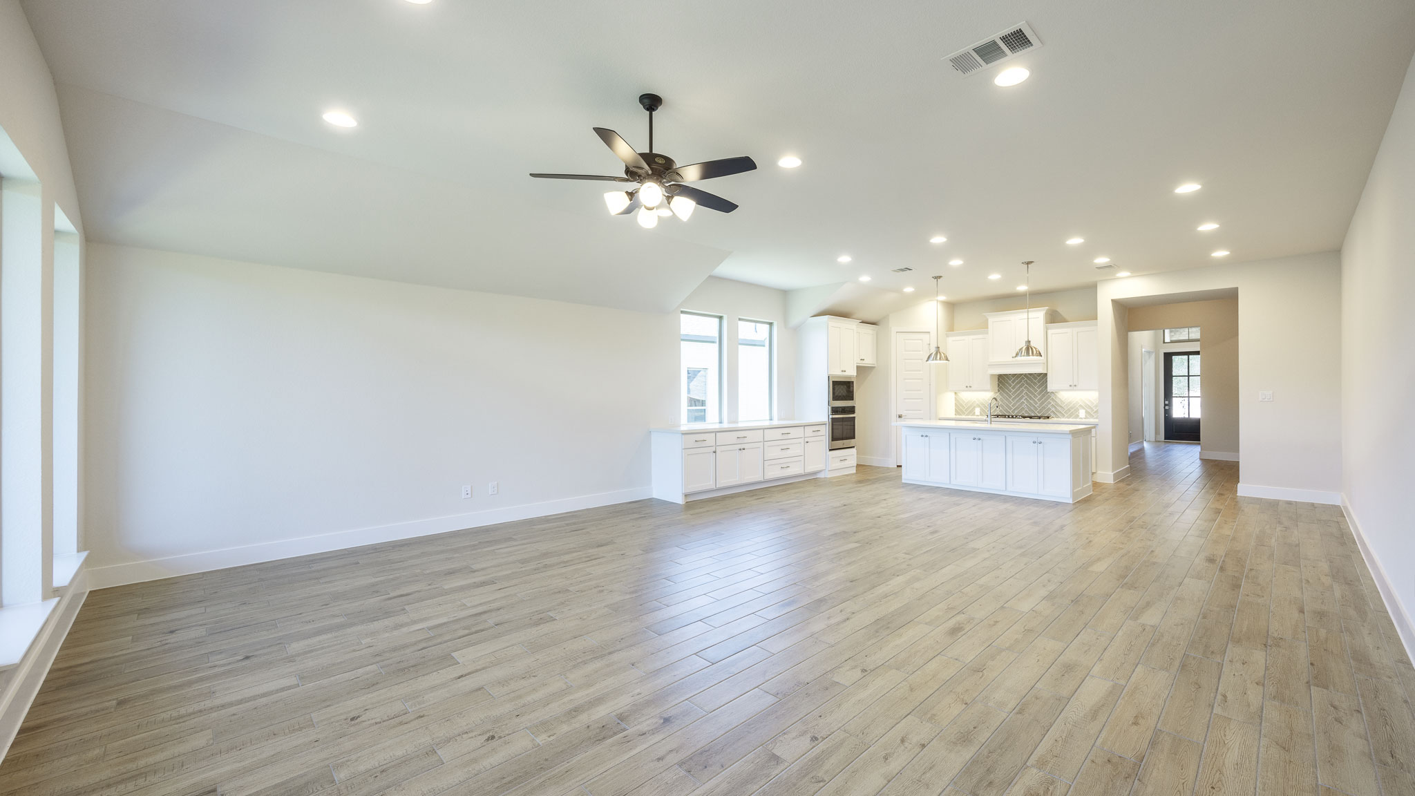 208 Meadow Beauty Lane Georgetown, TX 78633 - Photo 8 of 16 Unfurnished living room featuring recessed lighting, light wood-type flooring, a ceiling fan, and vaulted ceiling