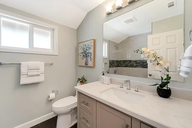 a bathroom with a sink toilet and a mirror