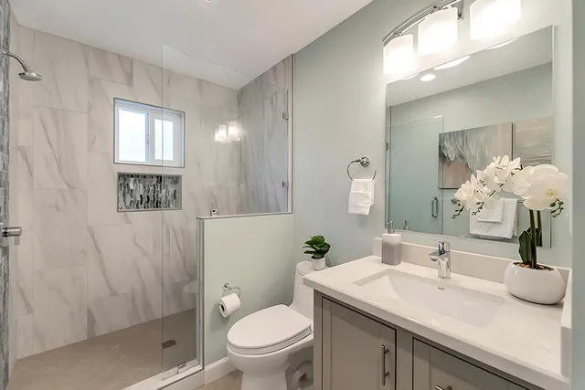 a bathroom with a sink a toilet and shower