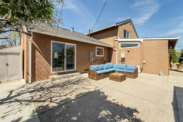 a view of a house with backyard and sitting area