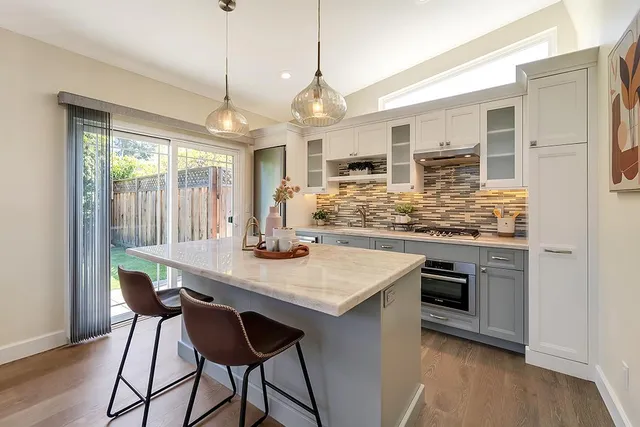 a kitchen with stainless steel appliances granite countertop a stove and a wooden floors