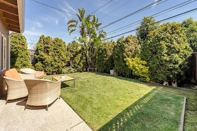 a view of a patio with table and chairs with wooden fence