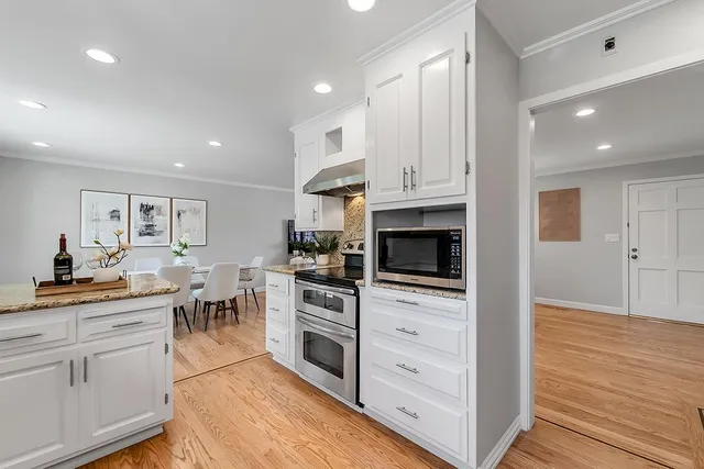 a kitchen with white cabinets and appliances
